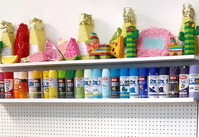 shelf of spray paint in rainbow order
