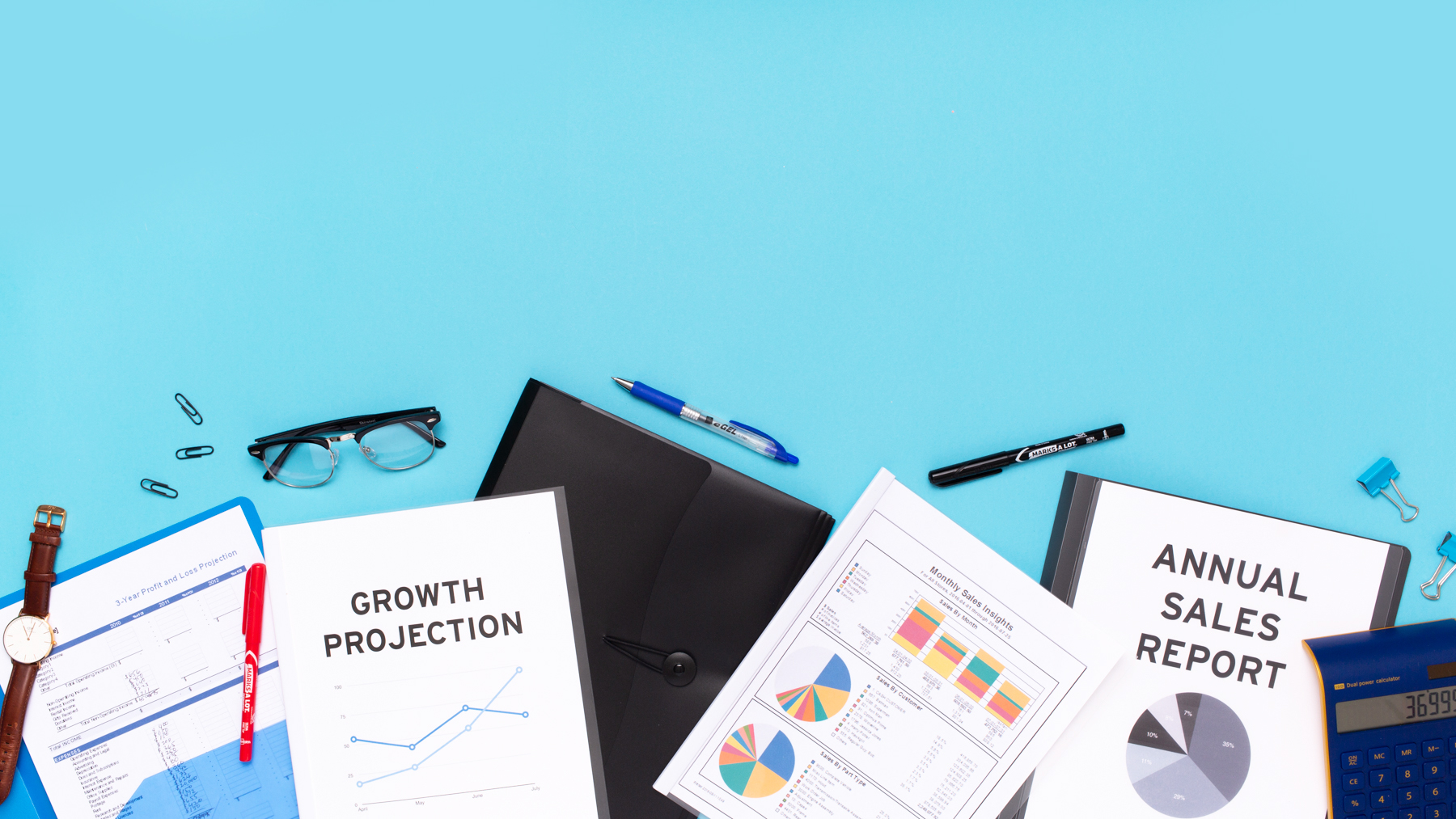 flatlay of business docutments: growth projection, sales reports, folders, office supplies