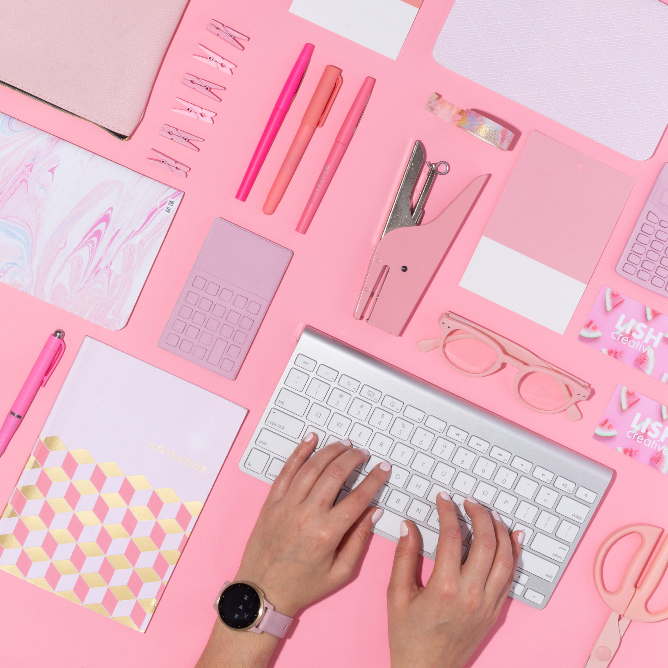 neat spread of pink office supplies