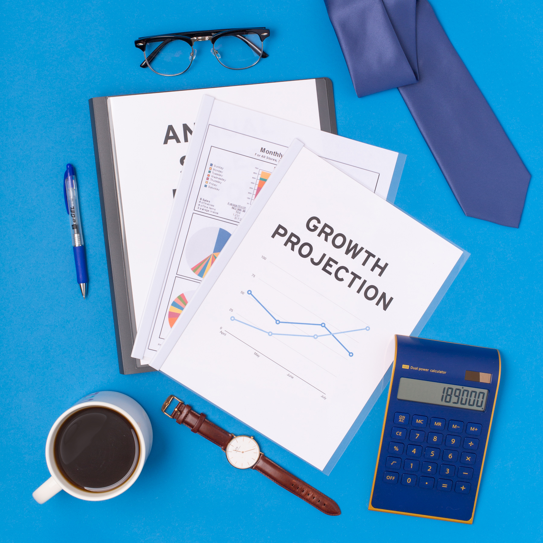 photo of desk supplies and business documents, including a booklet titled "growth projection"
