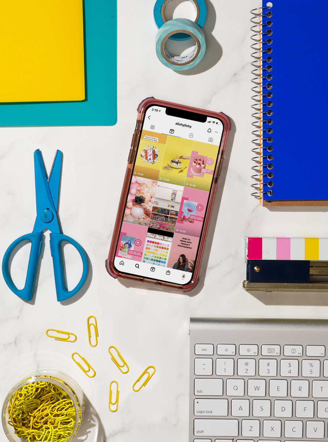phone with instagram feed on screen laying among office supplies