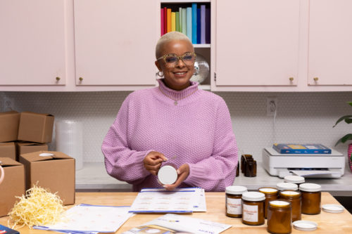 woman smiling in her office with products