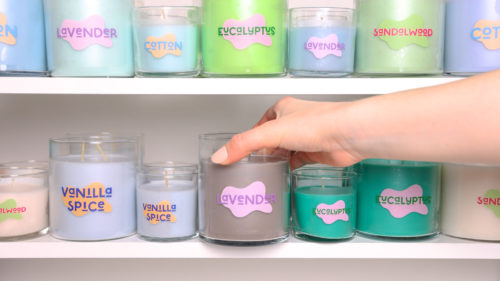 candles displayed on a shelf with custom Avery labels